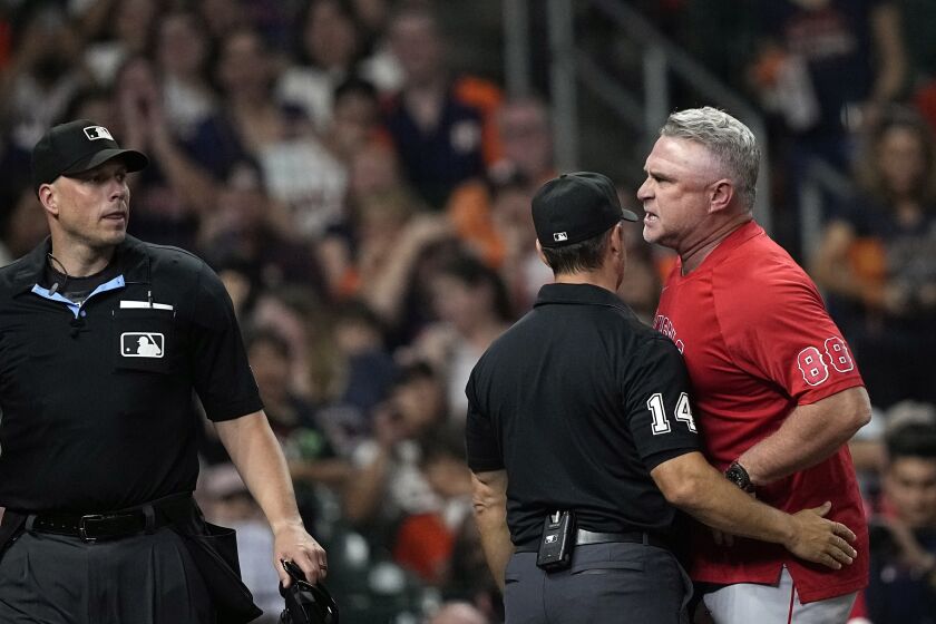 Second base umpire Mark Wegner (14) steps in-between home plate umpire Stu Scheurwater, left, and Los Angeles Angels manager Phil Nevin (88) during the sixth inning of a baseball game against the Houston Astros Thursday, June 1, 2023, in Houston. Nevin was ejected after arguing a strike-three call on Taylor Ward. (AP Photo/David J. Phillip)