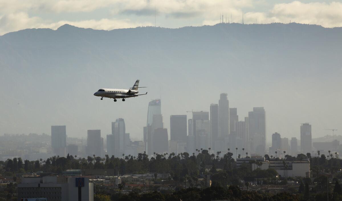 A plane in front of the Los Angeles skyline.