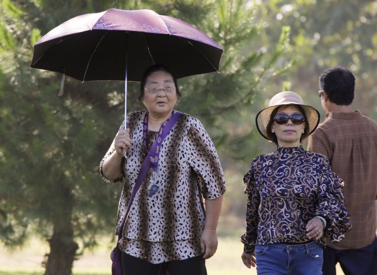 Umbrellas are required equipment while walking around Vincent Lugo Park as temperatures rise during the latest heat wave.