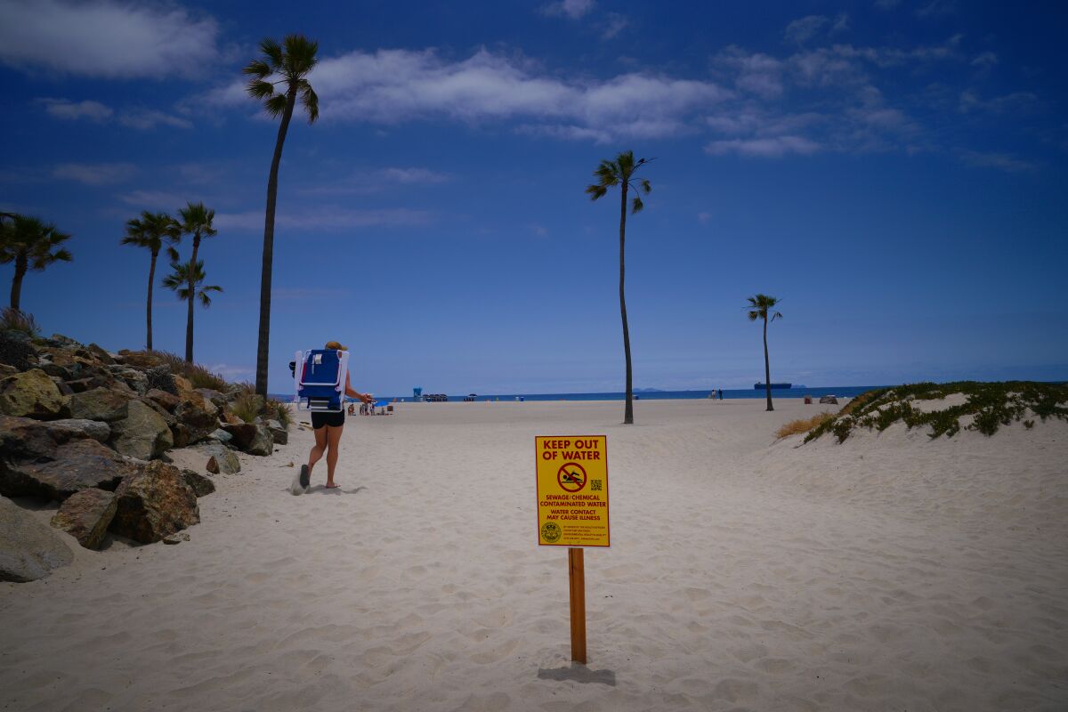 A sign telling people not to get in the water was posted at a beach entrance in Coronado on Friday.