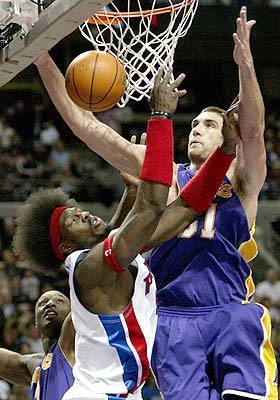 Detroit Pistons' Ben Wallace drives on Los Angeles Lakers' Chris Mihm, right, as Lamar Odom watches.