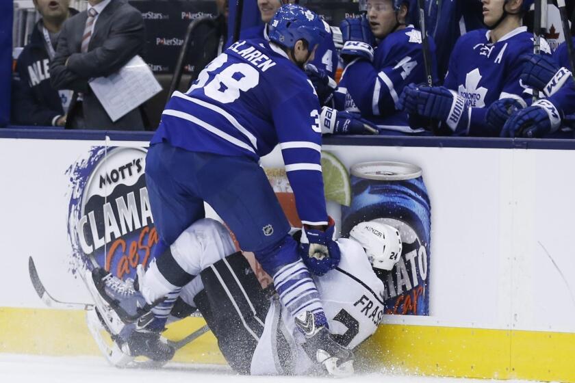 Kings center Colin Fraser, bottom, falls to the ice after being hit into the boards by Toronto's Frazer McLaren during a game on Dec. 11. Fraser suffered a concussion on the play.