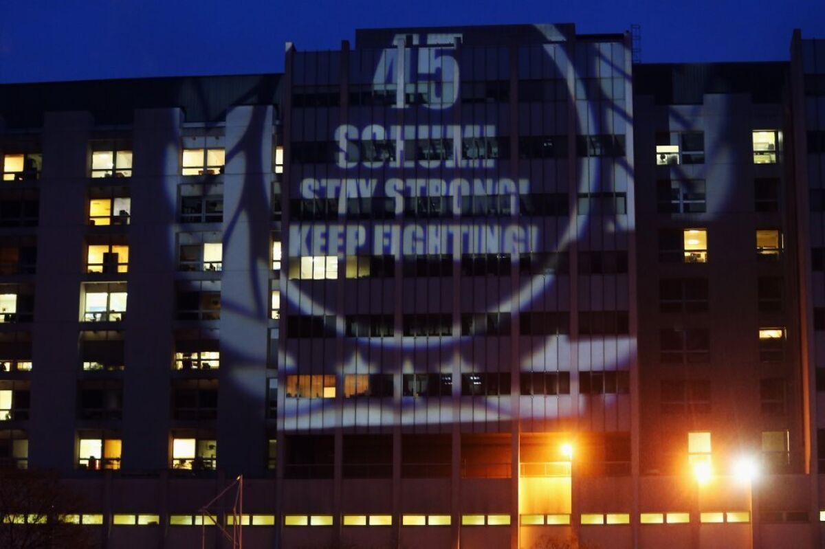 Fans project a message reading "45 -- Schumi Stay strong! Keep fighting!" on a wall of Grenoble University Hospital, where former Formula One driver Michael Schumacher is being treated.
