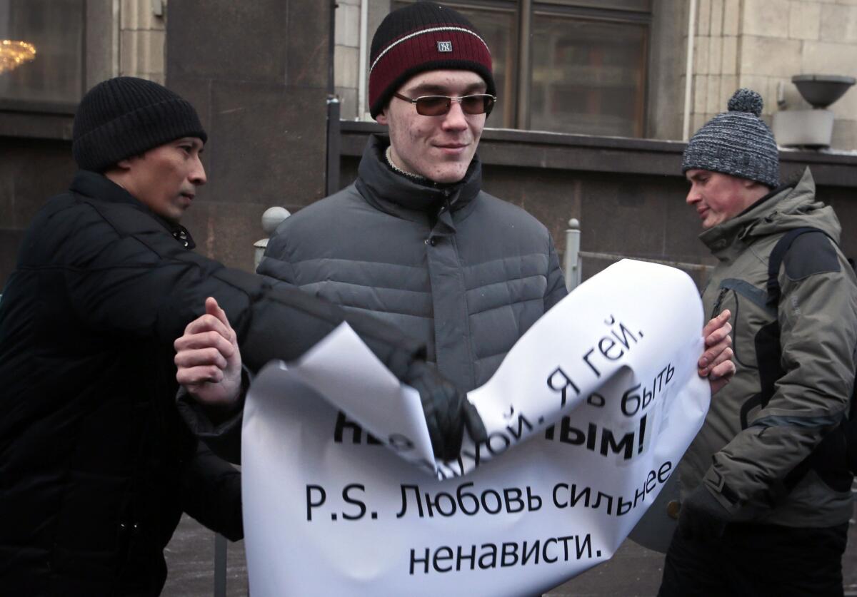 A supporter of a bill banning "homosexual propaganda" tries to grab a poster from the hands of a gay rights activist during a protest near the State Duma in Moscow on Friday.
