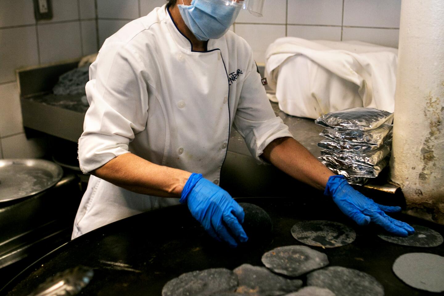 Lupita Ortiz Morelos, a cook at the popular seafood restaurant Contramar in Mexico City, makes tostadas on a comal.