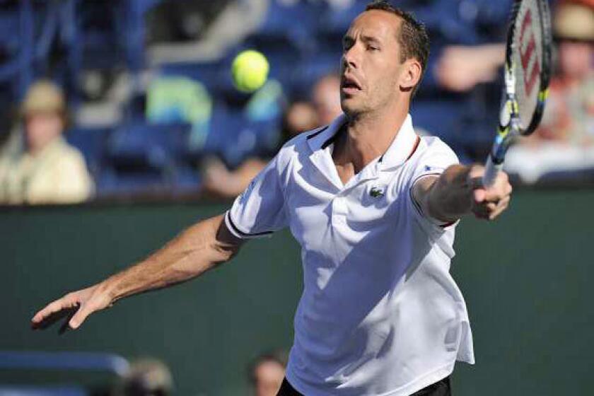 Michael Llodra hits a return against Jo-Wilfried Tsonga on Tuesday. Llodra retired from the match due to a leg injury, perhaps from sticking his foot in his mouth.