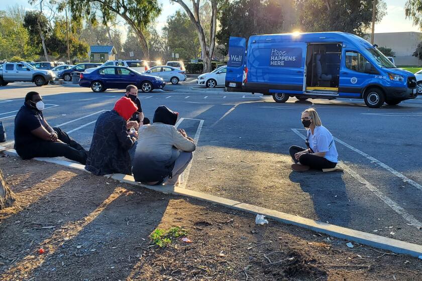 A member of Be Well OC's Mobile Crisis Response Team performs outreach to people living in Huntington Beach.