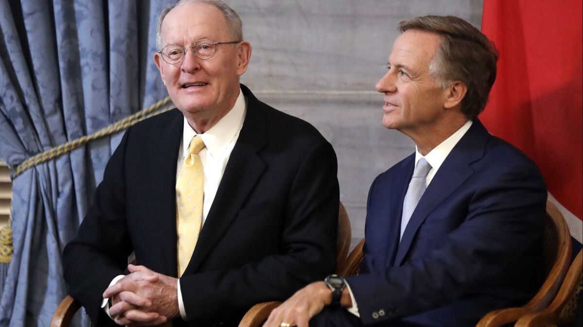 Sen. Lamar Alexander (R-Tenn.) left, sits with outgoing Tennessee Gov. Bill Haslam during a ceremony unveiling Haslam's official portrait in Nashville on Monday.