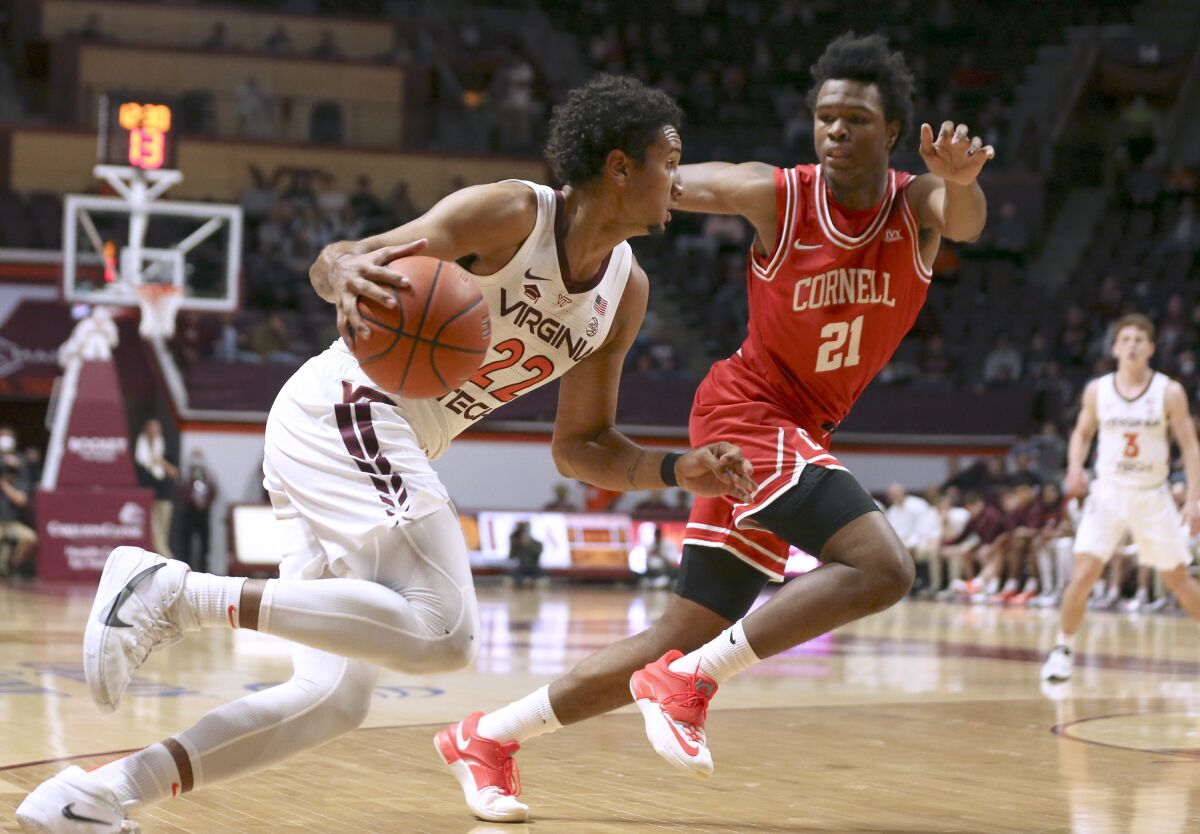 Virginia Tech's Keve Aluma (22) drives while defended by Cornell's Guy Ragland Jr. (21) during the first half of an NCAA college basketball game Wednesday, Dec. 8 2021, in Blacksburg, Va. (Matt Gentry/The Roanoke Times via AP)