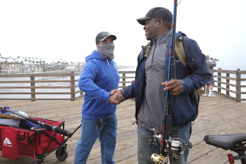 Oceanside, CA_5_9_24_|Fisherman Jose Rodriguez, left, greets fisherman Sean Foster, both of Oceanside as the Oceanside Pier opened Friday morning. "The fish missed us," said Foster who was the first person to catch a fish, a croaker within minutes of dropping a line.| The Oceanside Pier opened Friday at 7am to the delight of fishermen and walkers who have been unable to get on the pier due to a fire on Thursday April 25th. Photo by John Gastaldo for the Union-Tribune