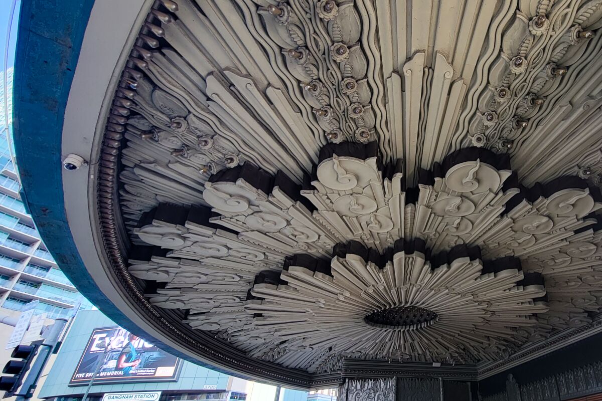 An entry canopy's ceiling is decorated with a huge medallion that looks like a blooming flower.