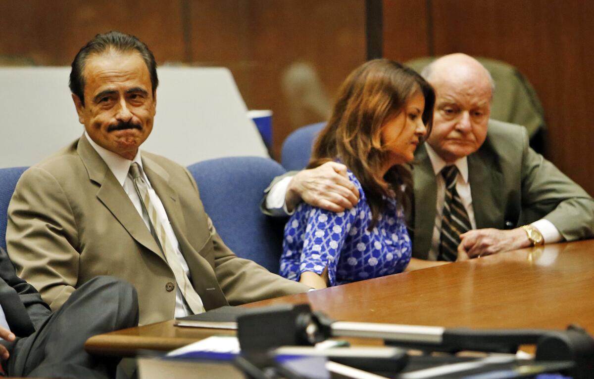 Former Los Angeles City Councilman Richard Alarcon, left, reacts as his wife, Flora Montes de Oca Alarcon is comforted by her attorney Mark E. Overland, right, as verdicts are read on voter-fraud and perjury charges.
