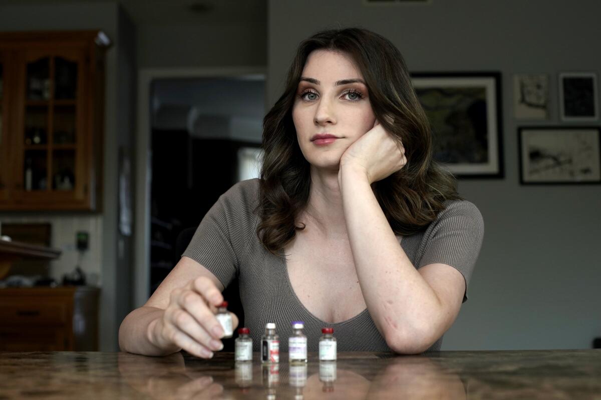 Transgender woman Stacy Cay displays bottles of hormone therapy drugs