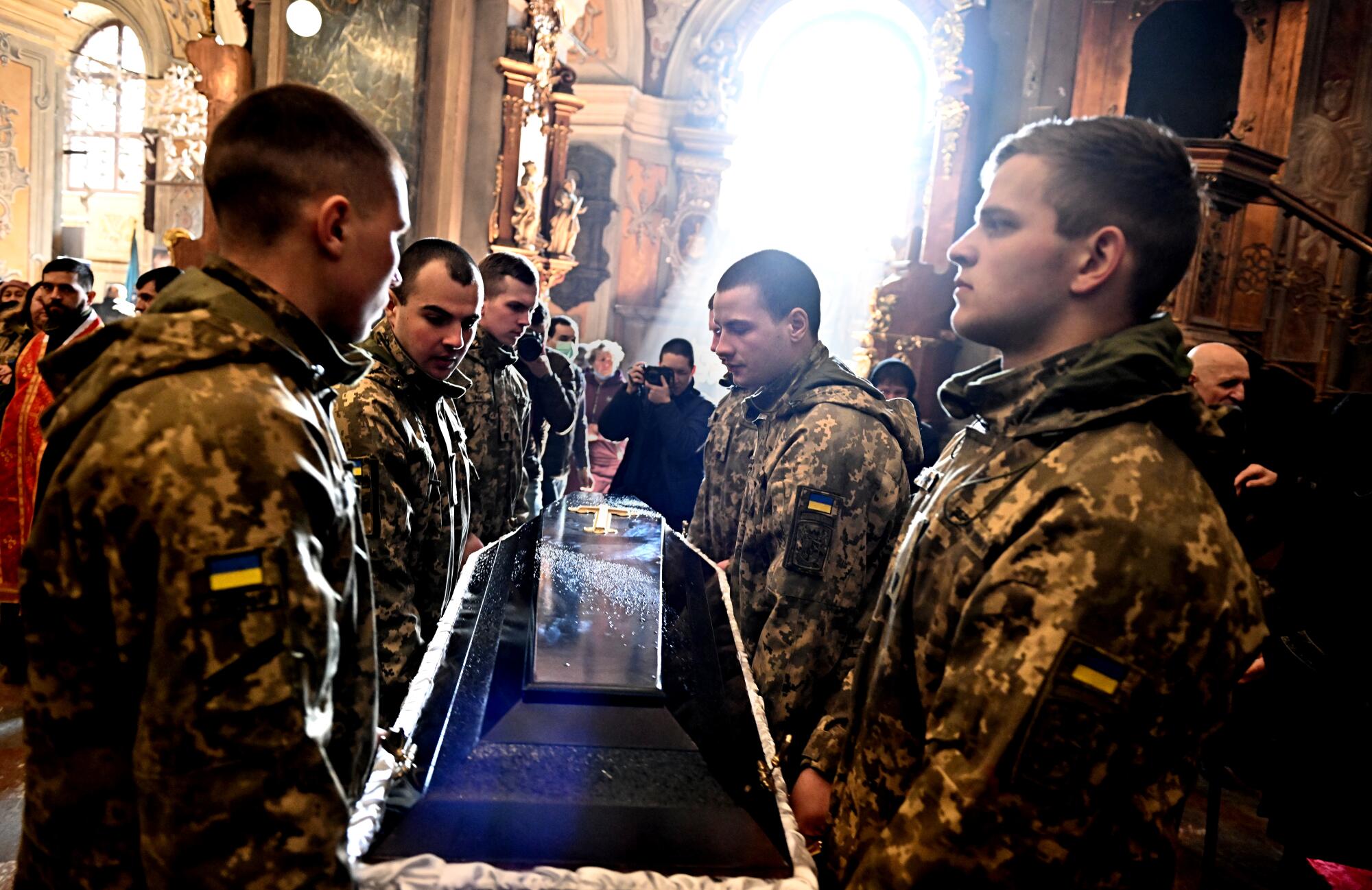 Ukrainian Soldiers carry the casket of Ivan Skrypnyk at the Church of St. Peter and Paul in Lviv Thursday. 