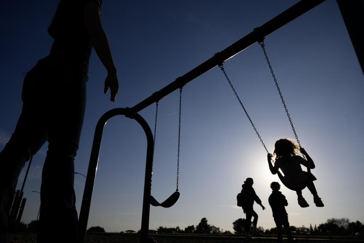 Alexia Carbone pushes her 5-year-old transgender daughter "A." on a swing.