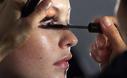 She isn't born with it: A model has mascara applied backstage before the spring 2010 Lacoste collection.