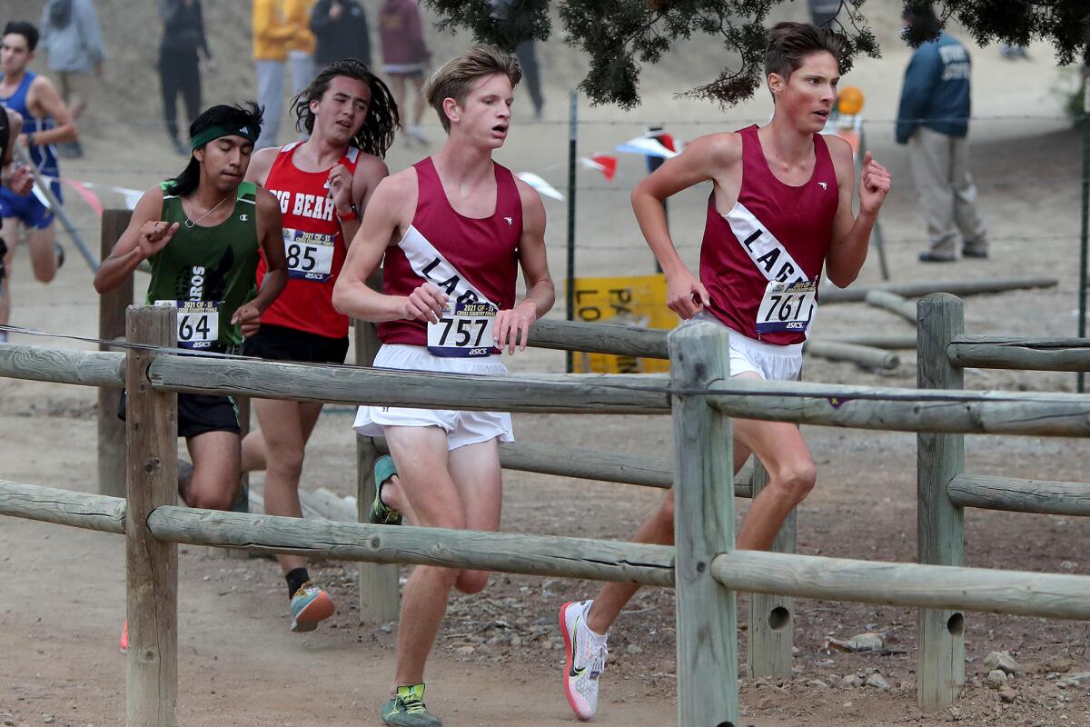 Laguna Beach senior Mael Metis, right, and junior Chris Drews, center, run in the Division 4 boys' race.