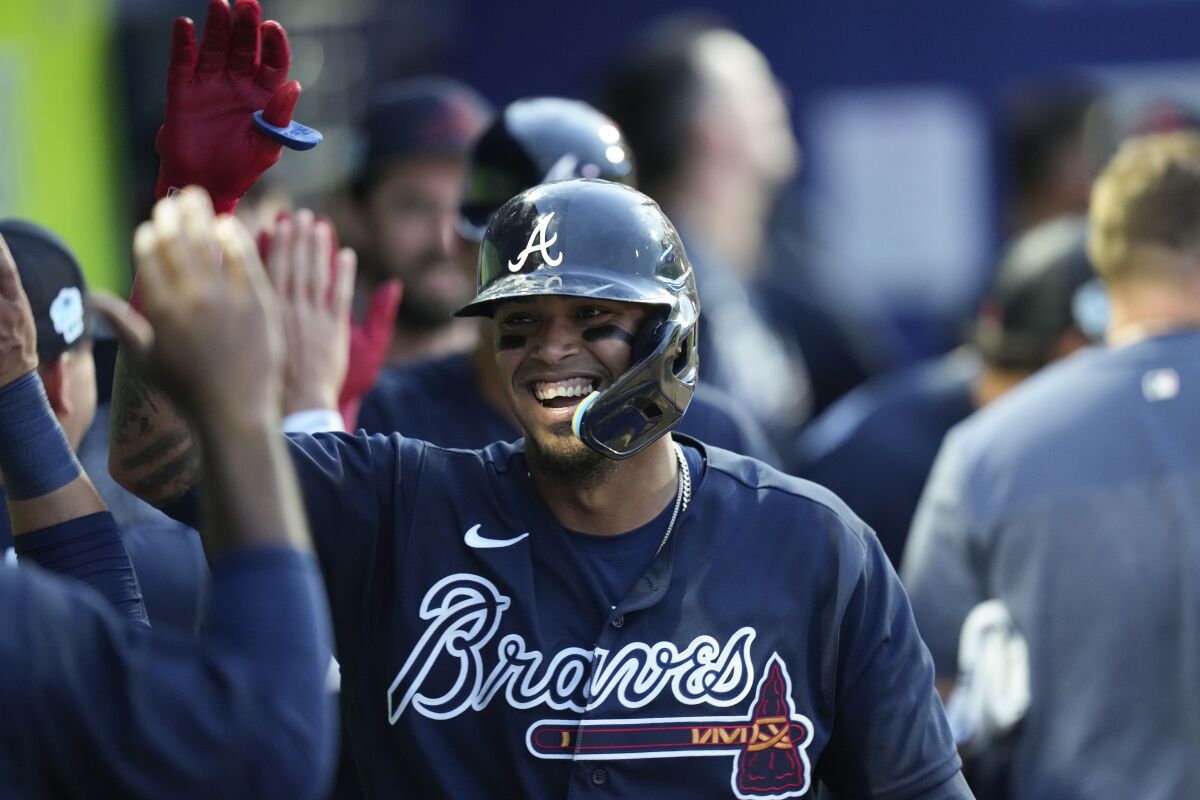 Atlanta Braves Orlando Arcia is greetedin the dugout after his two-run homer in the sixth inning of a spring training baseball game against the Philadelphia Phillies in North Port, Fla., Saturday, March 18, 2023. (AP Photo/Gerald Herbert)