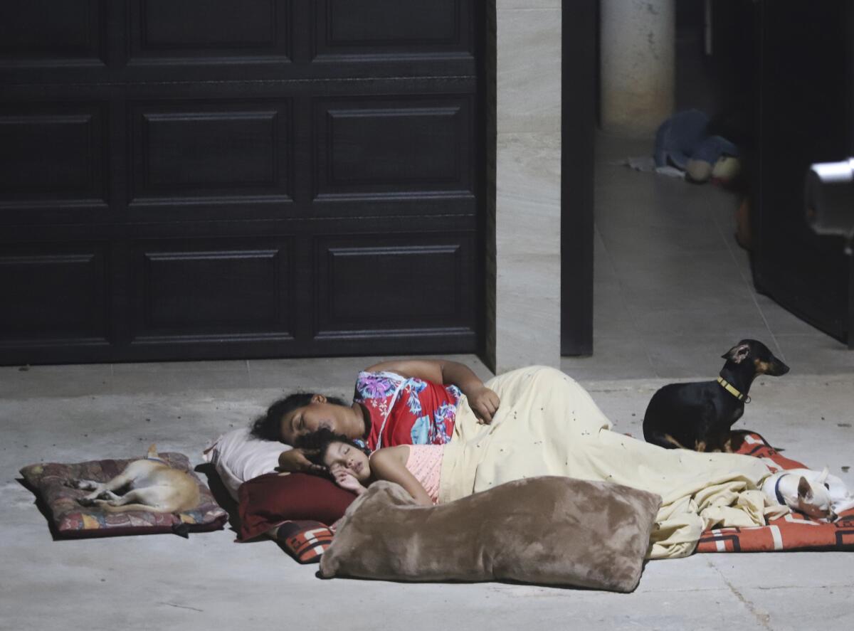 Una mujer y una niña duermen afuera de su casa tras un terremoto, en Acapulco, México.