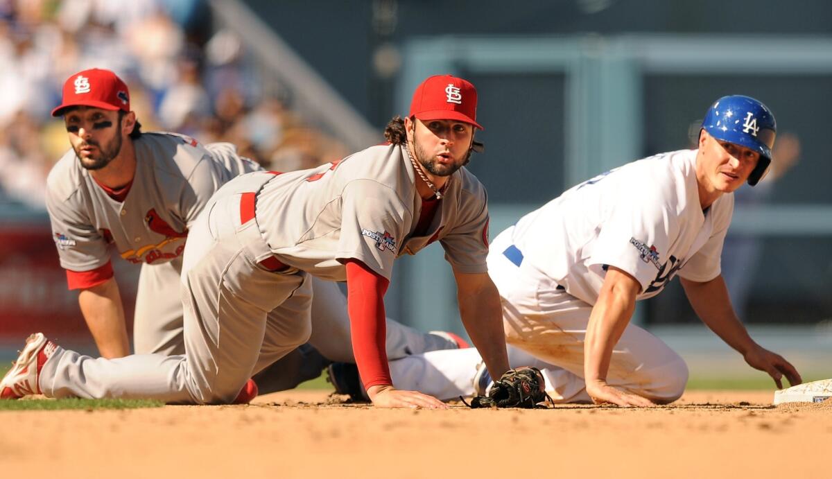Dodgers second baseman Mark Ellis, right, Cardinals shortstop Pete Kozma, center, and Cardinals second baseman Matt Carpenter look toward first to see that a double play was completed in the third inning of Game 5.