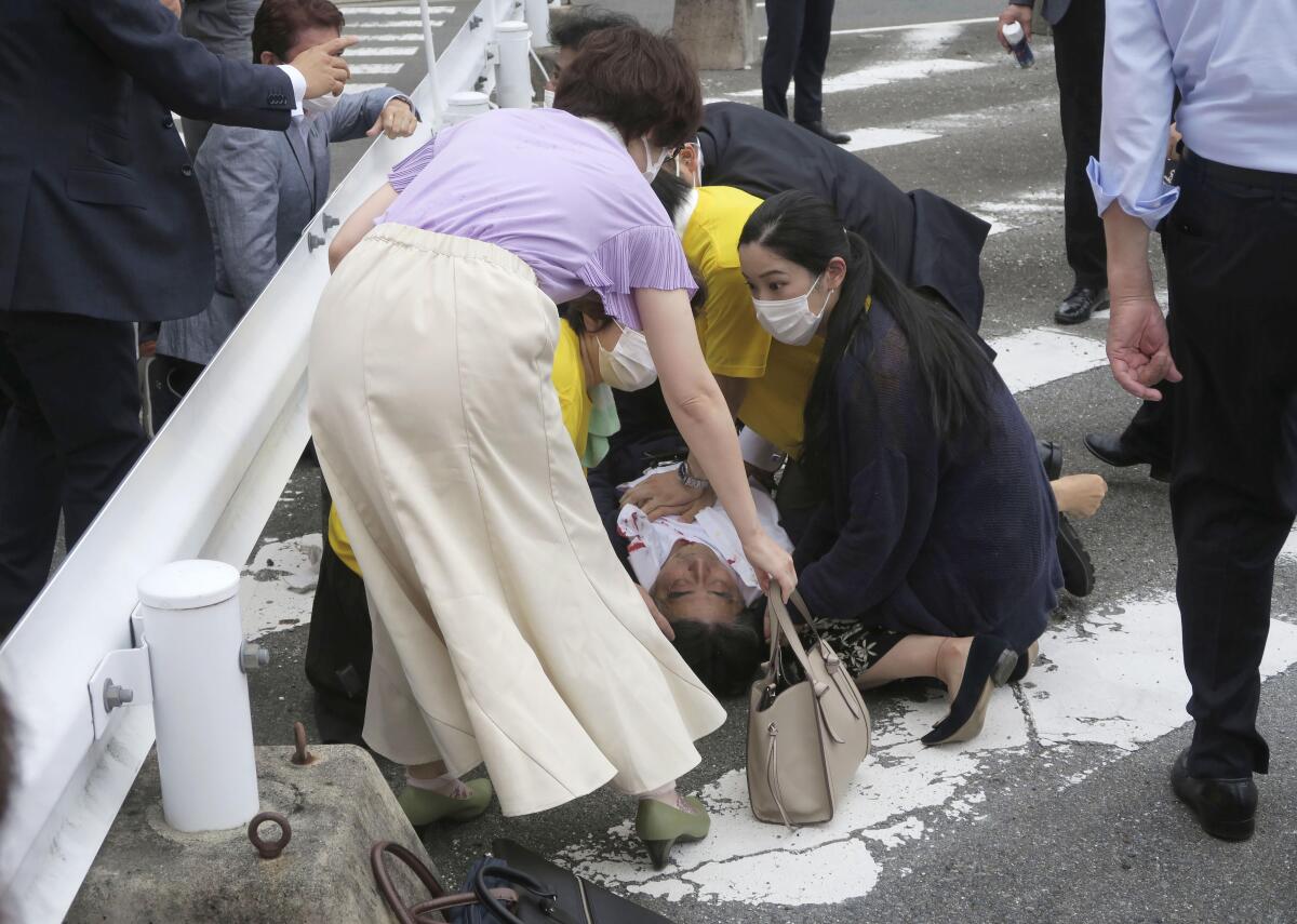 El ex primer ministro japonés Shinzo Abe, al centro, yace en el piso tras ser baleado el viernes 8 de julio de 2022, en Nara