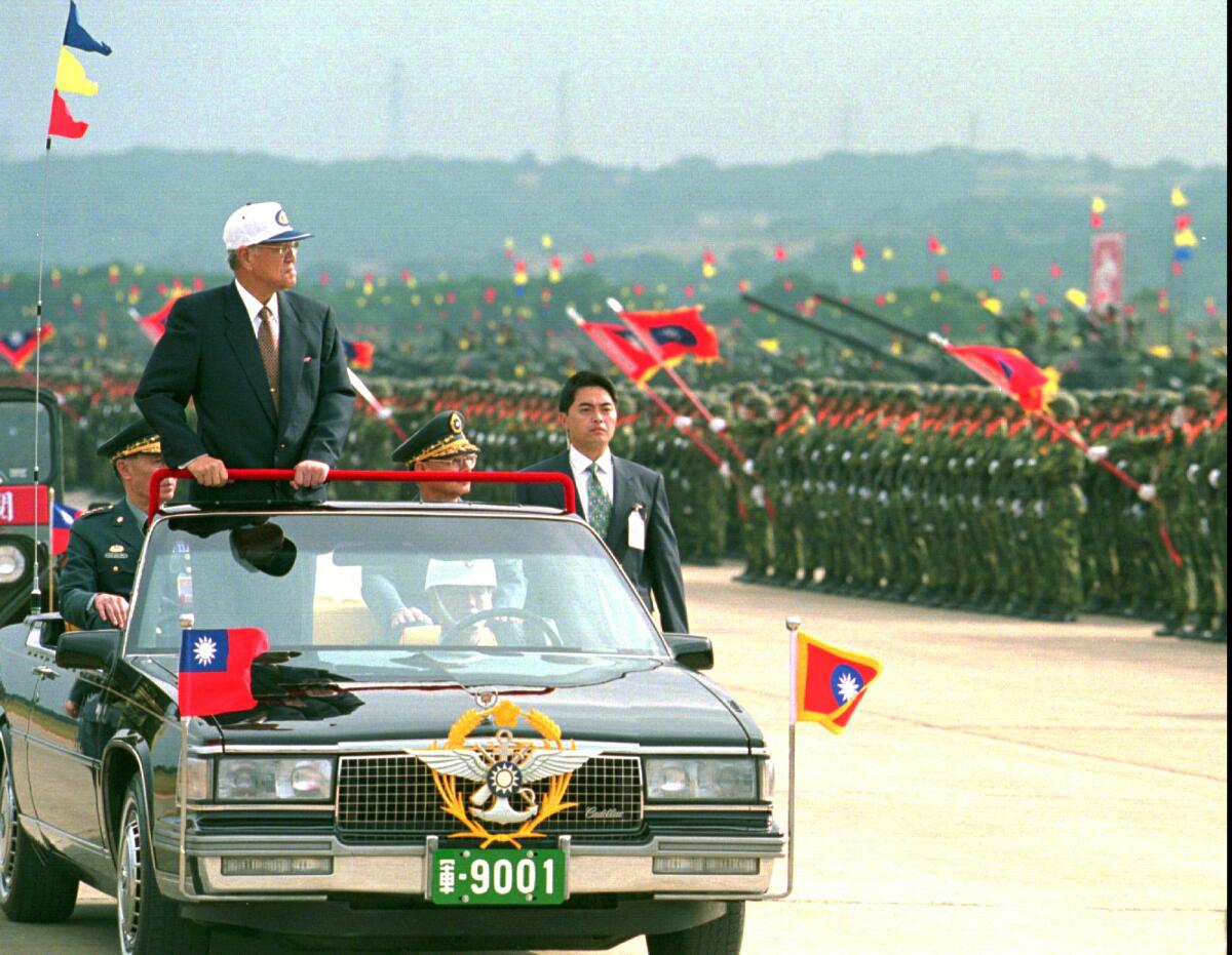 Taiwanese President Lee Teng-hui rides in an open limousine as he inspects armored divisions in 1997.
