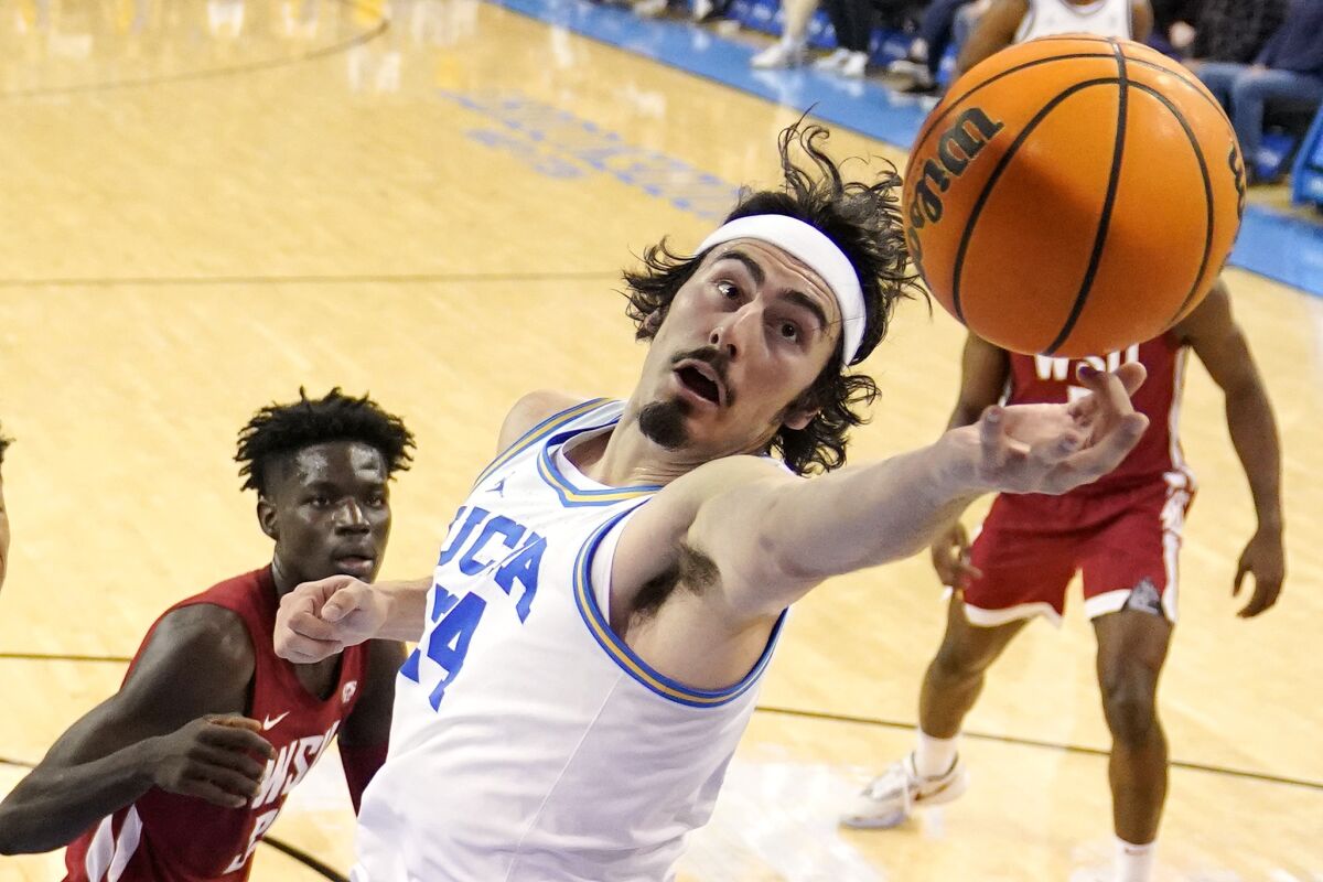 UCLA's Jaime Jaquez Jr. reaches for a rebound in front of Washington State's Mouhamed Gueye.