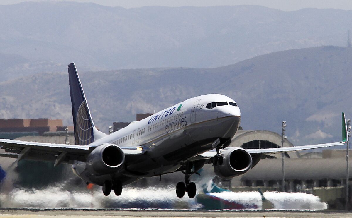 An airliner lifts off from John Wayne Airport before beginning its steep climb