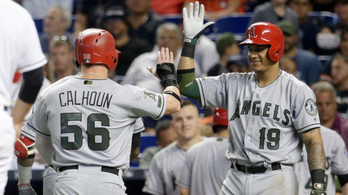 Angels' Kole Calhoun (56) is met by Jefry Marte (19) after scoring on a two-run home run hit by Martin Maldonado during the fifth inning against the Miami Marlins on May 28.
