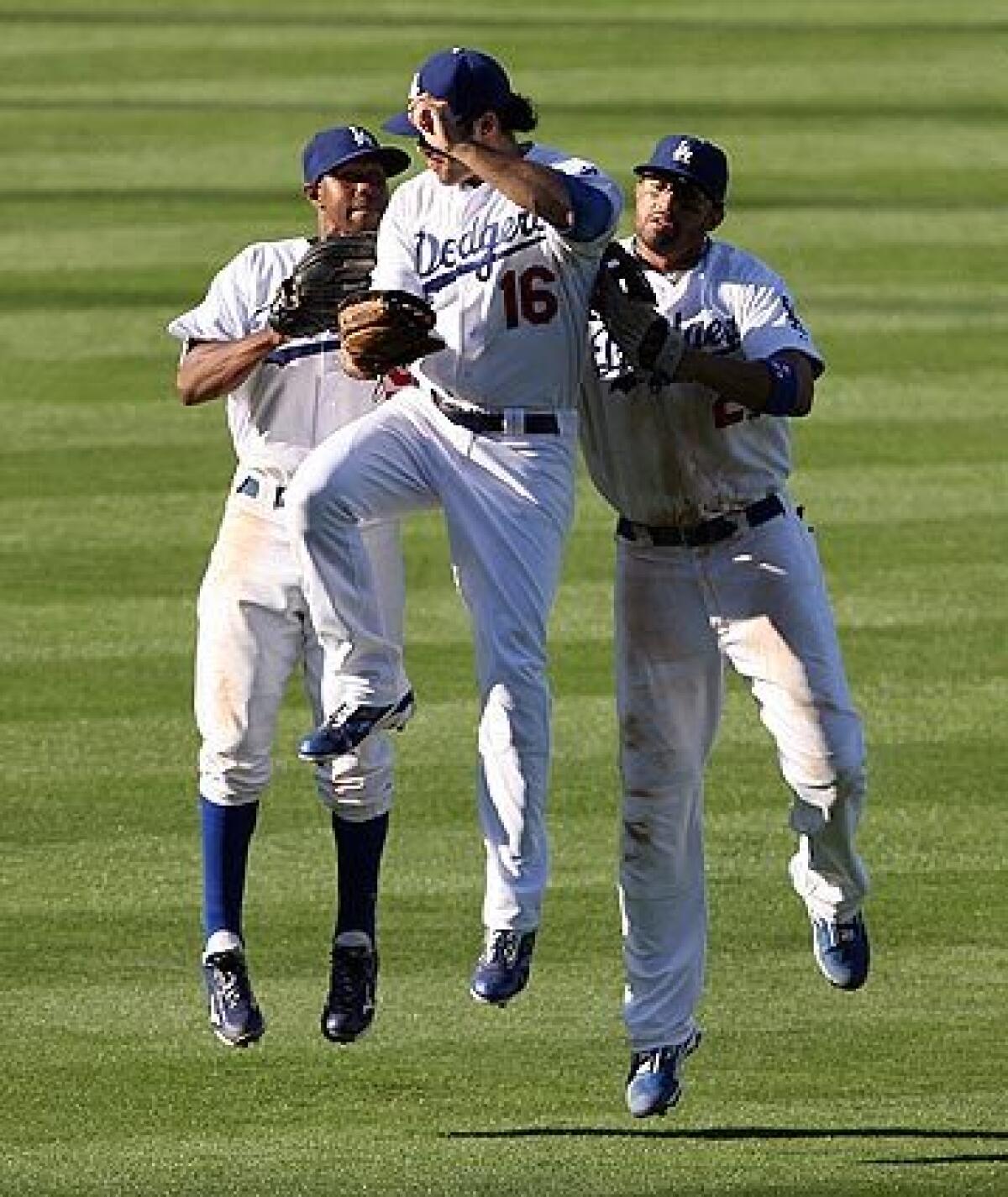 Dodgers outfielders Juan Pierre (left), Andre Ethier (16) and Matt Kemp body bump after beating the Philadelphia Phillies, 2-1, on Friday at Dodger Stadium to even the National League Championship Series at 1-1.