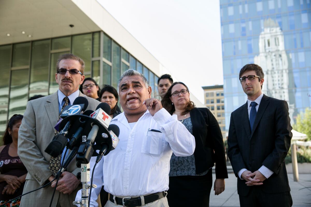 Aureliano Santiago, a street vendor, center, answers questions from reporters during a news conference outside of L.A. police headquarters. Street vendors and their allies are suing Los Angeles in federal court over the alleged seizure of their carts and other belongings, arguing that the practice is unconstitutional.