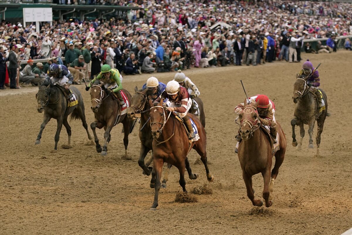 Rich Strike, lower right, crosses the finish line to win the 148th running of the Kentucky Derby on Saturday.