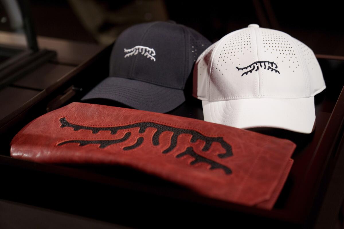 Merchandise from Tiger Woods' new line, including a blue hat and a white one, both featuring a tiger logo