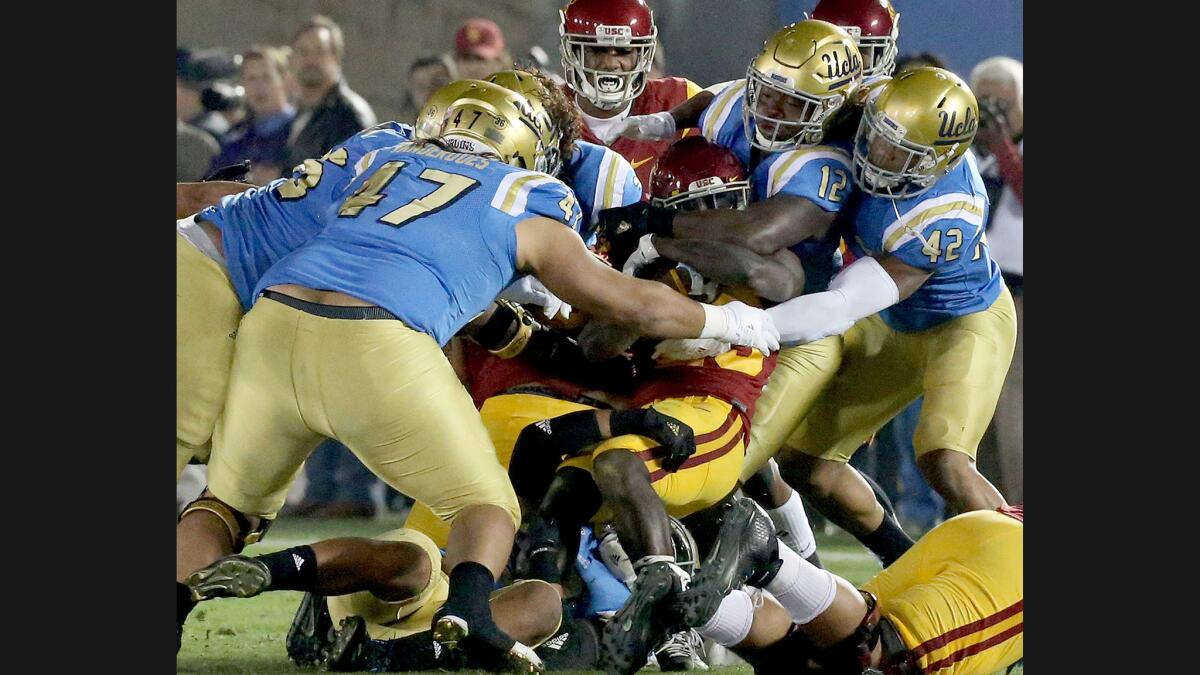 The UCLA defense puts the wraps on USC tailback Ronald Jones II during the first quarter of a game at the Rose Bowl on Nov. 19.