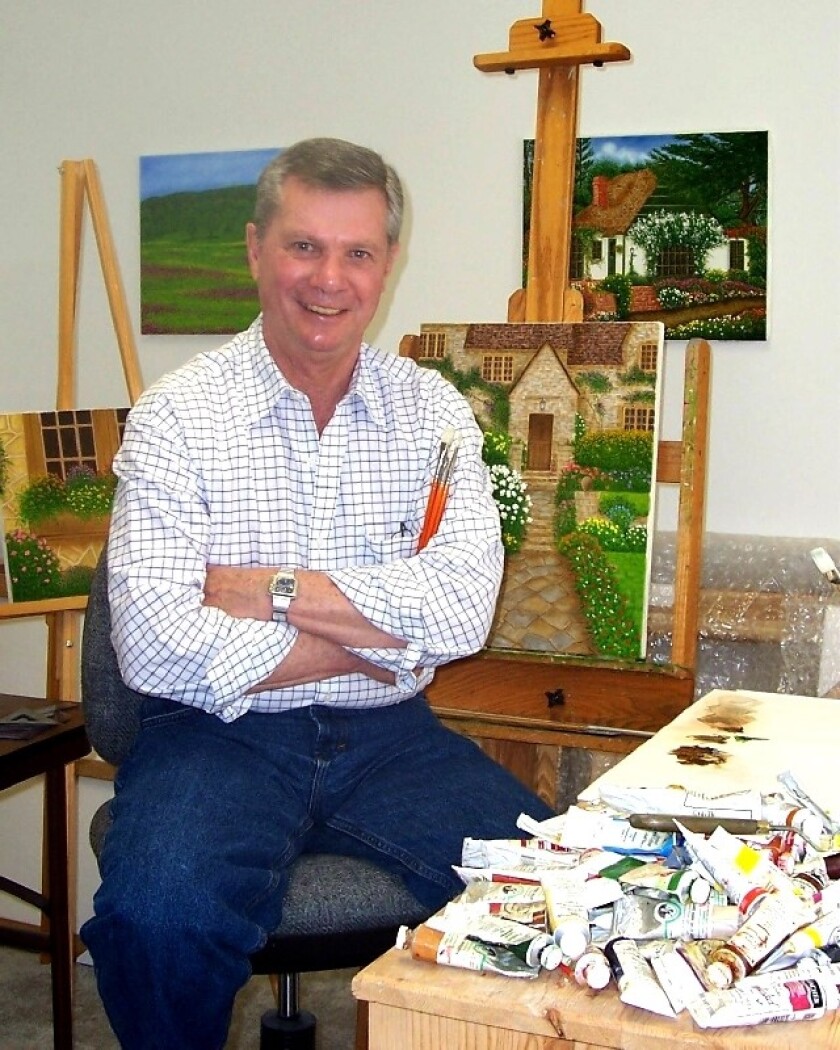 A man posing with paintings on easels.