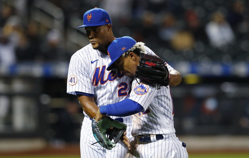 New York Mets relief pitcher Jeurys Familia (27) hugs Francisco Lindor after the top of the seventh inning against the Arizona Diamondbacks in a baseball game Saturday, May 8, 2021, in New York. (AP Photo/Noah K. Murray)