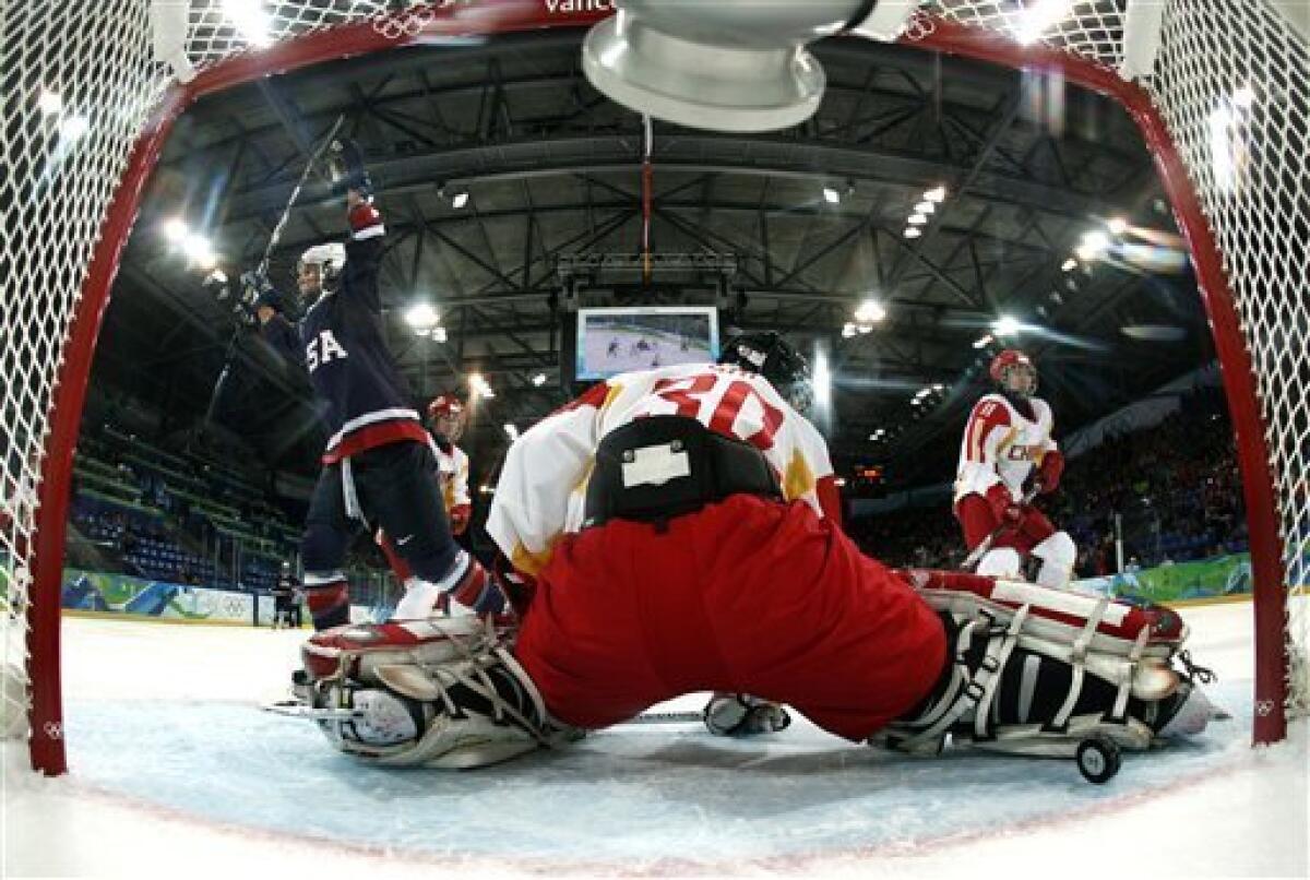 USA's forward Kelli Stack , left, celebrates after scoring past China's goal keeper Shi Yao (30) in the first period in women's preliminary round hockey play during the Vancouver 2010 Olympics in Vancouver, British Columbia, Sunday, Feb. 14, 2010. (AP Photo/Gene J. Puskar)