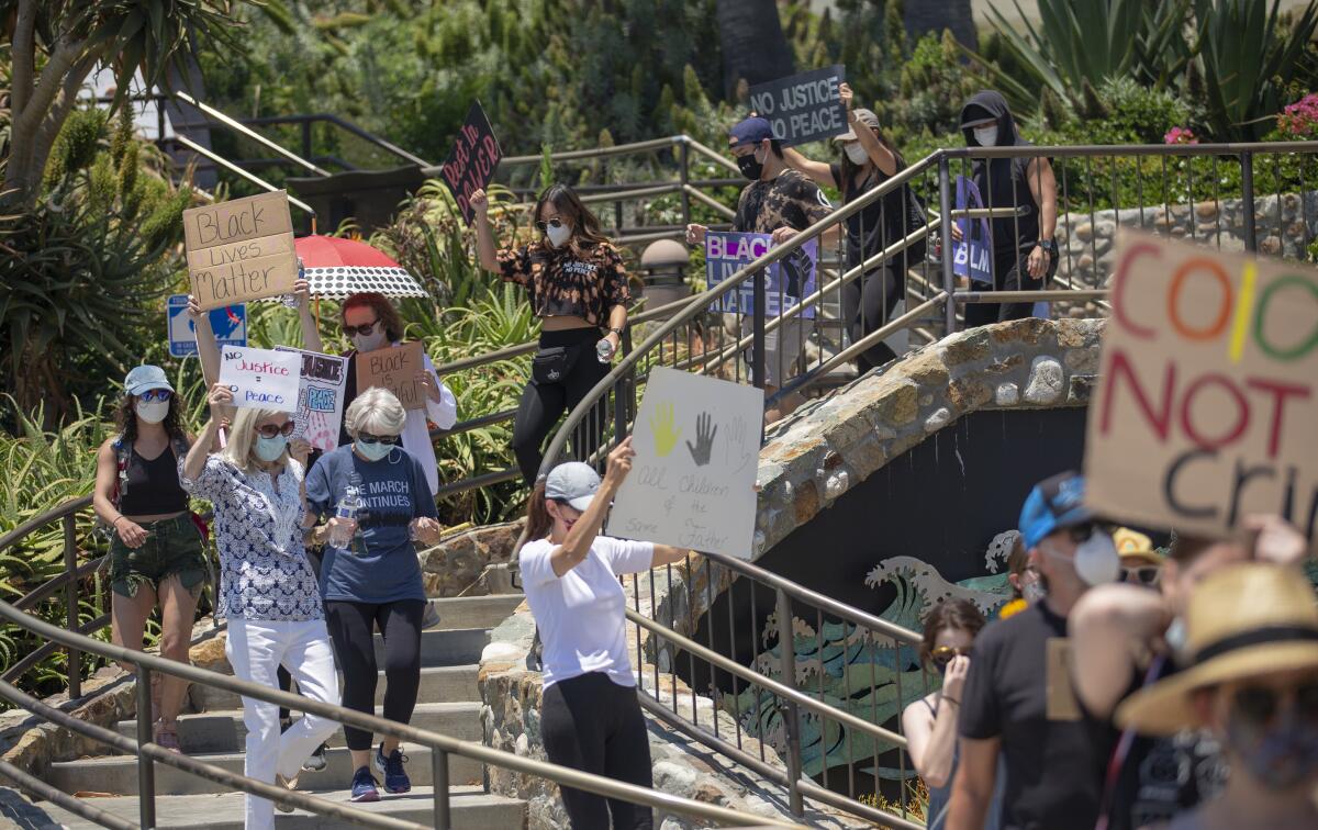 Protesters walk down the stairs on their way to Main Beach in Laguna Beach during a Black Lives Matter protest.