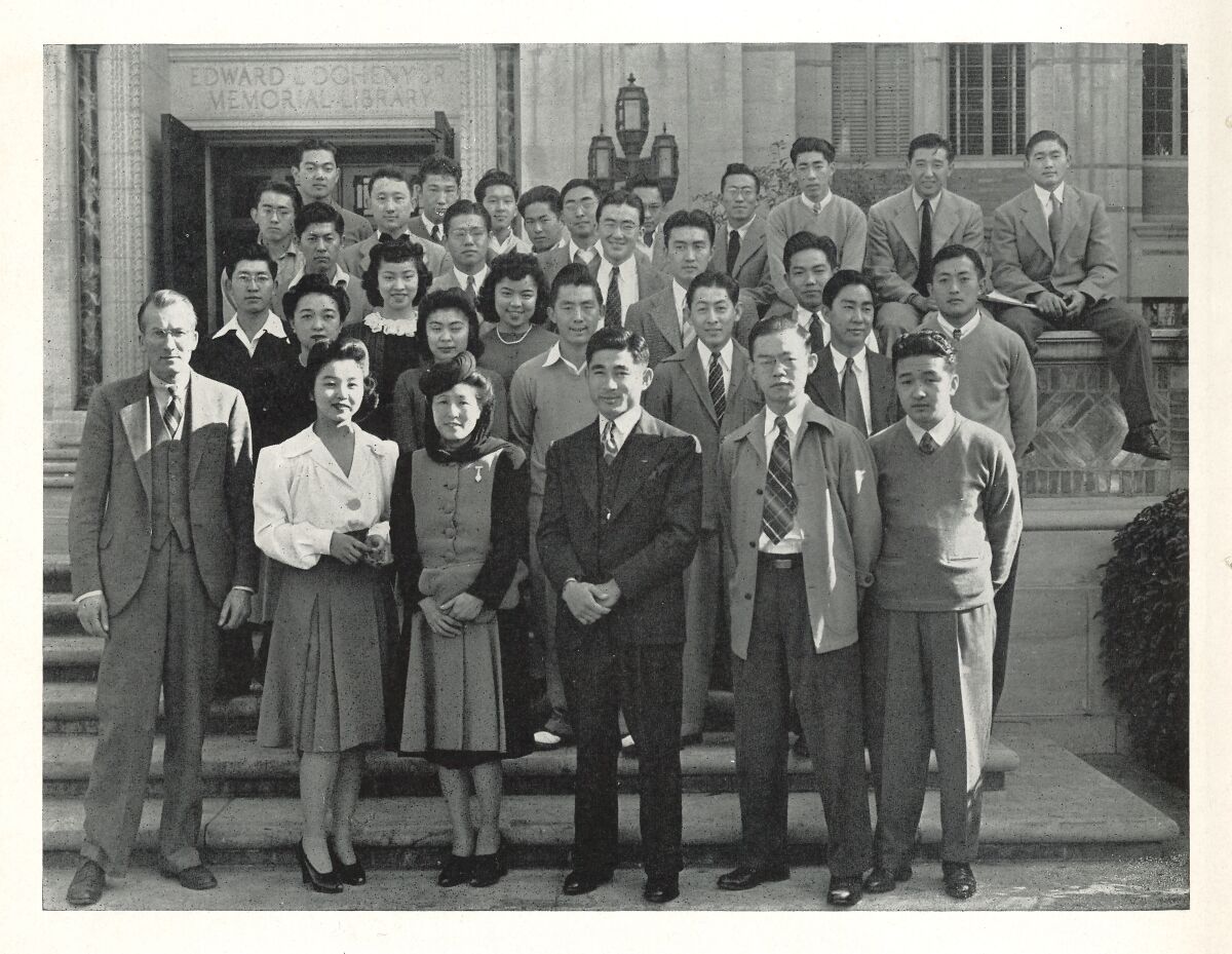 Students stand in front of the library in a yearbook photo