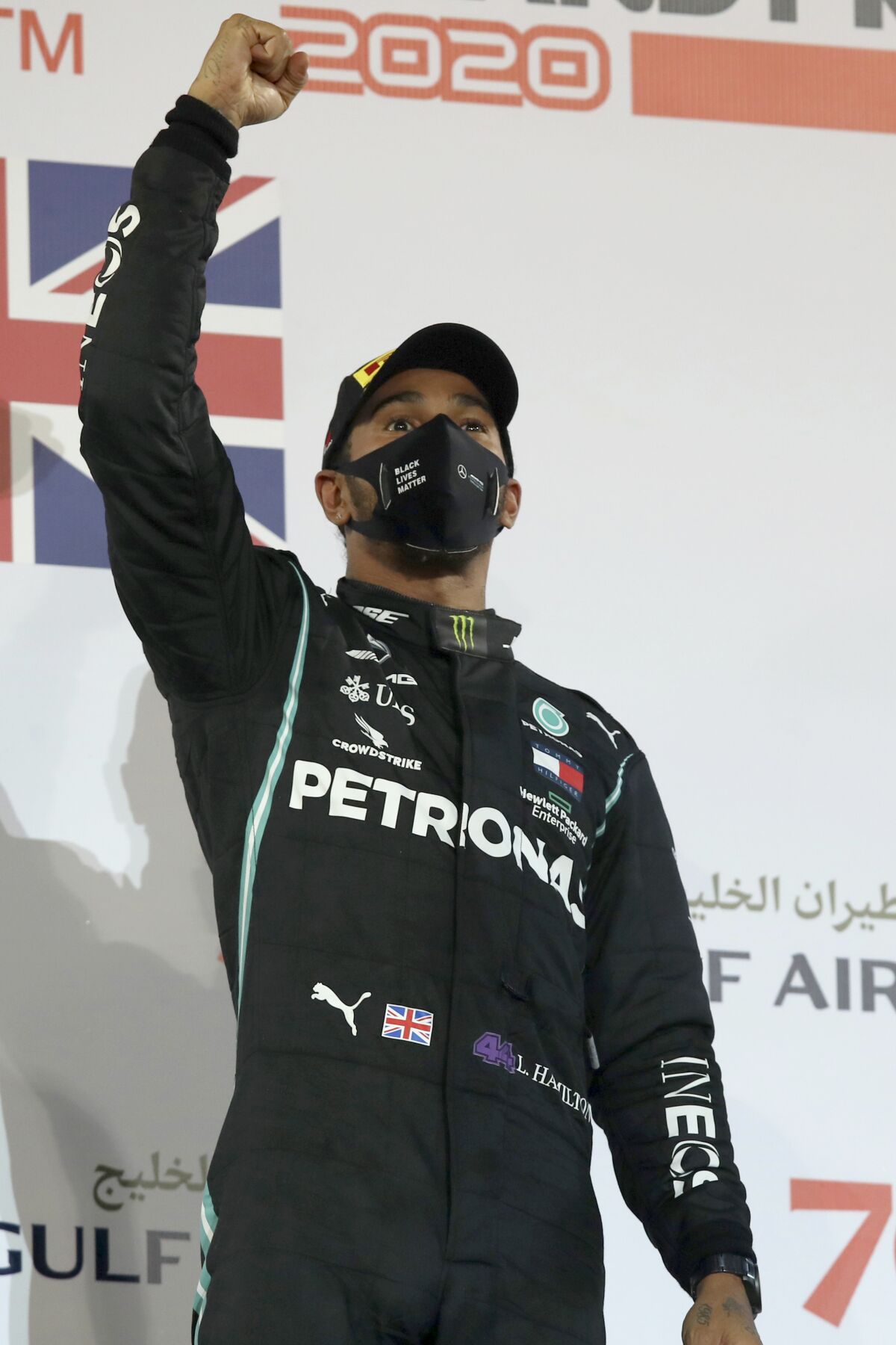 FILE - In this Sunday, Nov. 29, 2020 file photo Mercedes driver Lewis Hamilton of Britain celebrates after wining the Formula One race in Bahrain International Circuit in Sakhir, Bahrain. World champion Lewis Hamilton tested positive for COVID-19 and will miss the Sakhir Grand Prix this weekend, his Mercedes-AMG Petronas F1 Team said Tuesday Dec. 1, 2020. (Tolga Bozoglu, Pool via AP, File)