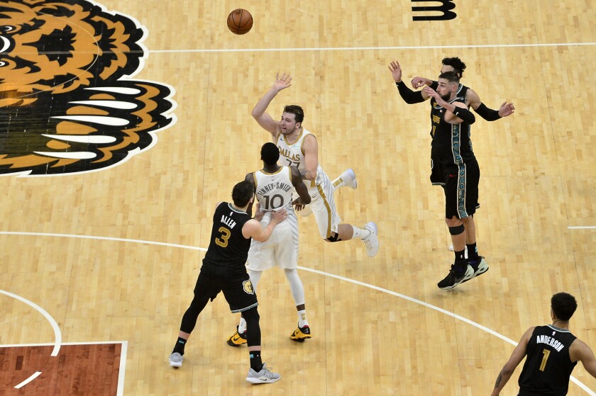 Dallas Mavericks guard Luka Doncic (77) takes the game-winning 3-point shot at the end of the second half of the team's NBA basketball game against the Memphis Grizzlies on Wednesday, April 14, 2021, in Memphis, Tenn. The Mavericks won 114-113. (AP Photo/Brandon Dill)