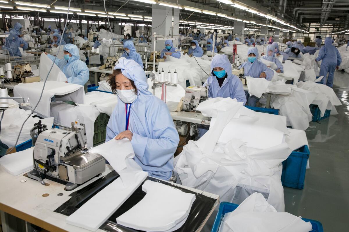 Trabajadores fabrican ropa para protegerse contra el coronavirus en una fábrica en Wuxi, en la provincia oriental china de Jiangsu, el 8 de febrero.