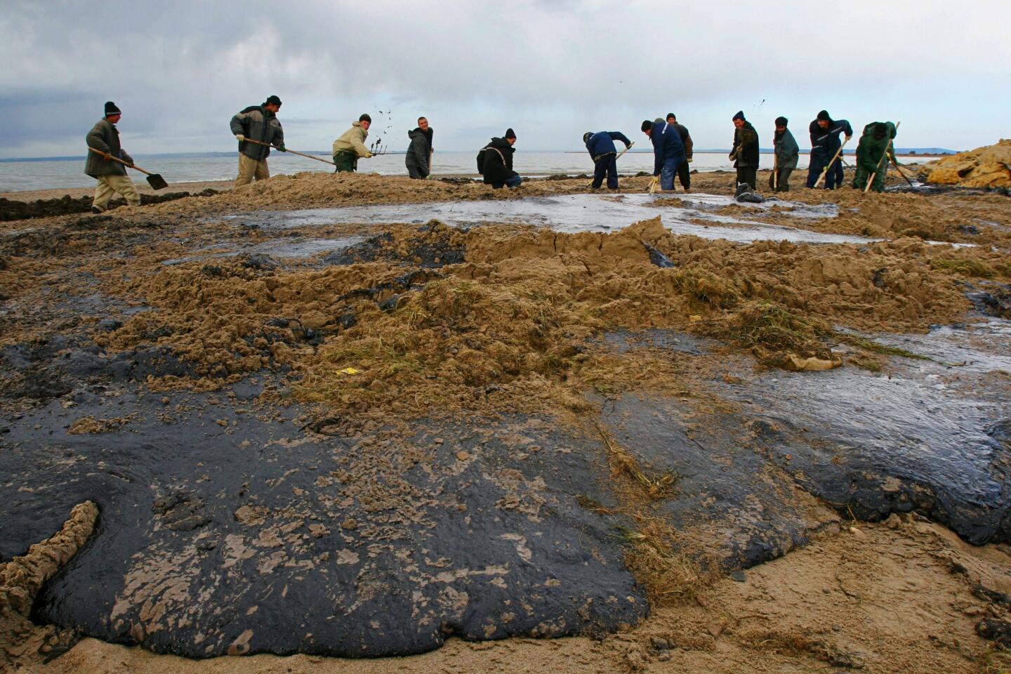 Workers labor to remove oil from the beach on Russia's Tuzla Spit after a tanker accident last weekend when a storm hit in the area of the Kerch Strait between the Black Sea and the Sea of Azov. "All of our problems are because of this oil," vineyard worker Alexander Ostapenko, 43, told The Times. "But what's in it for us? They are polluting our sea and land."