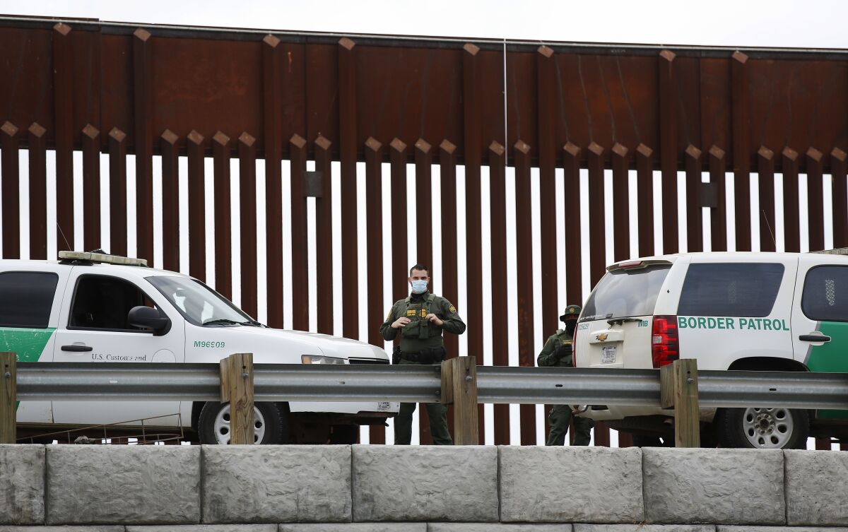 A U.S. Border Patrol agent stands guard at the U.S.- Mexico Border on Sunday, Oct. 25, 2020 .