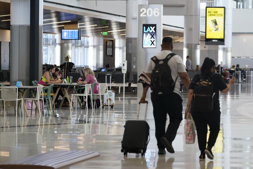 Passengers wait for their flights inside the new West Gates at Tom Bradley International Terminal at Los Angeles International Airport Monday, May 24, 2021, in Los Angeles. (AP Photo/Ashley Landis)