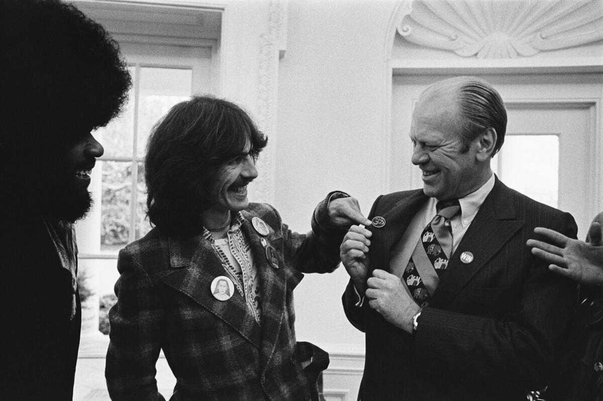 President Ford smiles as he meets two rock musicians. 