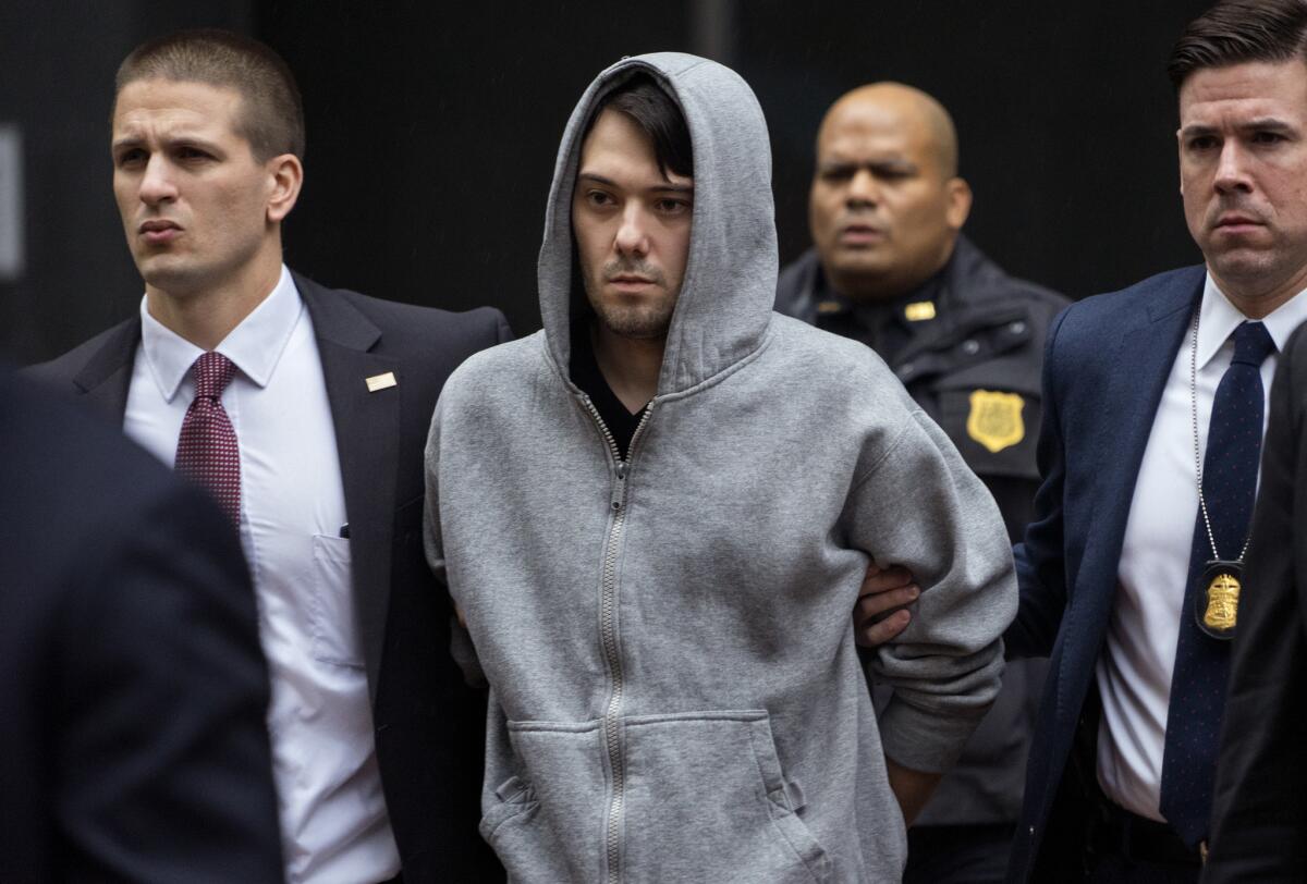 Martin Shkreli is escorted by law enforcement agents in New York on Thursday after being taken into custody following a securities probe.