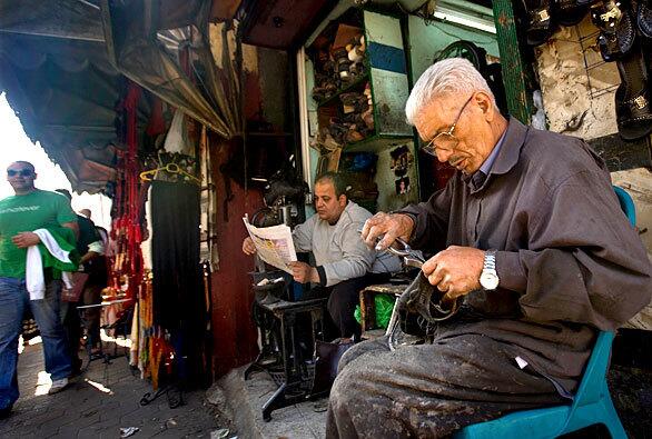 Fouad Bekheet, 65, sitting on the right, repairs shoes at a shop in Cairo. He has been hand-crafting footware and making repairs since he was 14 years old. When he first started in the trade, he made all repairs by hand; now he sometimes uses a sewing machine.