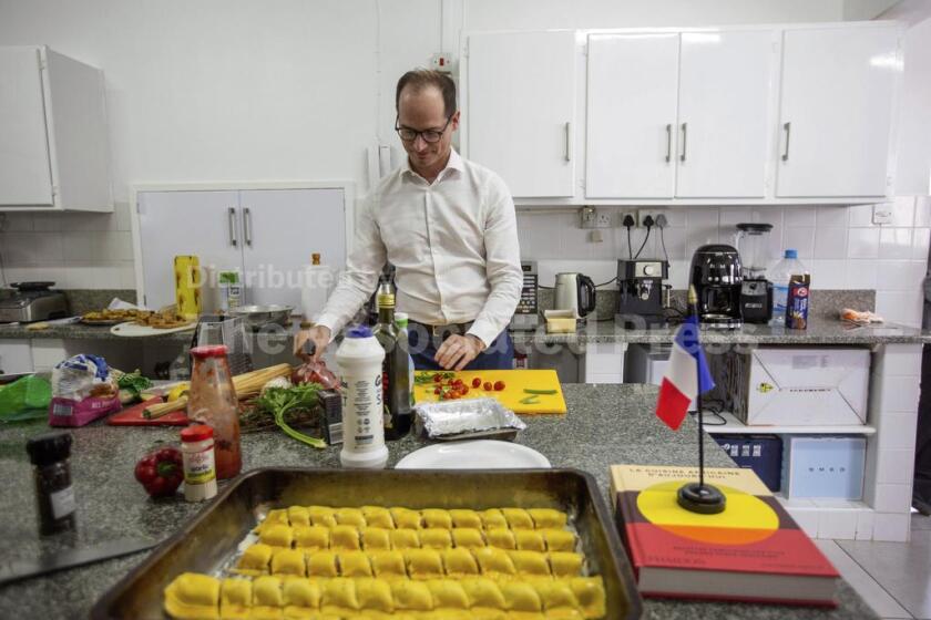 Paul-Bertrand Barets, embajador francés en Zimbabue, prepara un platillo en la cocina de la sede diplomática en Harare, Zimbabue, el miércoles 16 de marzo de 2025, para un concurso de cocina entre diversos diplomáticos extranjeros. (AP Foto/Aaron Ufumeli)
