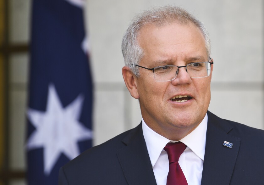 Australian Prime Minister Scott Morrison speaks to the media during a press conference at Parliament House in Canberra, Thursday, Feb. 4, 2021. Morrison says he has used his first telephone conversation with U.S. President Joe Biden to invite the new American leader Down Under this year to mark the 70th anniversary of a bilateral defense treaty. (Lukas Coch/AAP Image via AP)